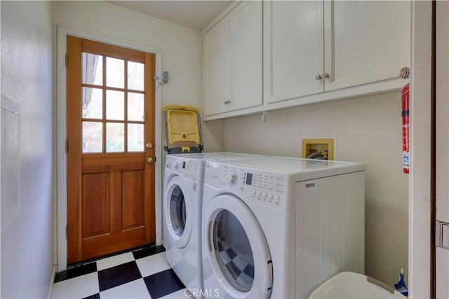 clothes washing area with cabinets and washer and dryer