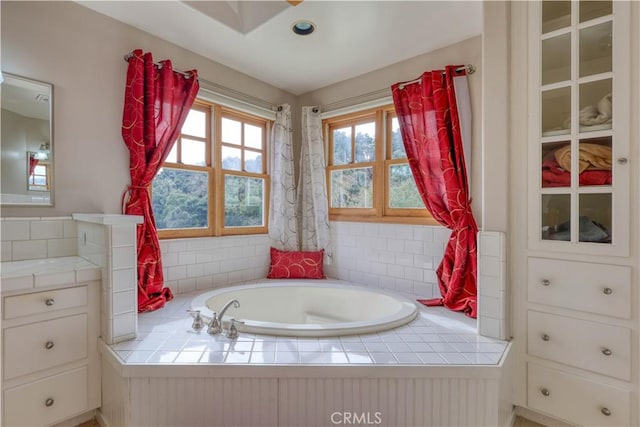 bathroom featuring vanity and tiled bath