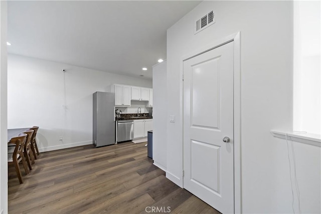 kitchen featuring stainless steel appliances, dark hardwood / wood-style floors, sink, and white cabinets