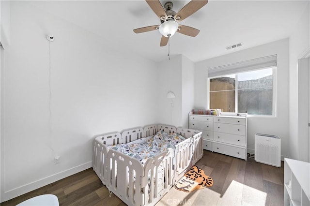 bedroom with dark hardwood / wood-style flooring and ceiling fan