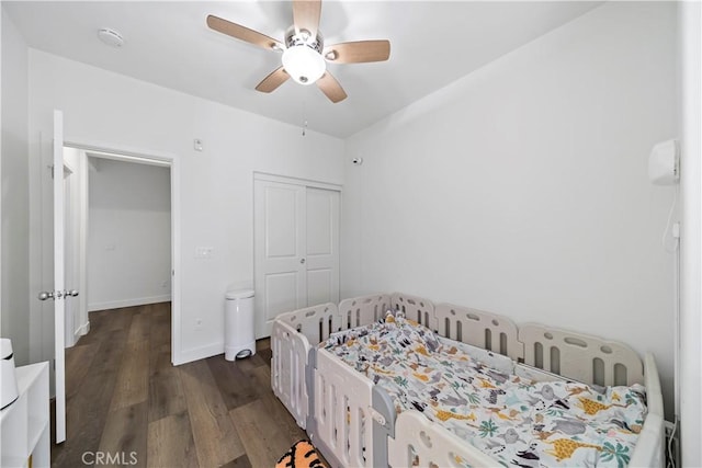 bedroom featuring ceiling fan, dark hardwood / wood-style flooring, and a closet