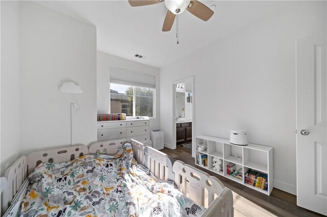 bedroom with ceiling fan, ensuite bathroom, and dark hardwood / wood-style flooring