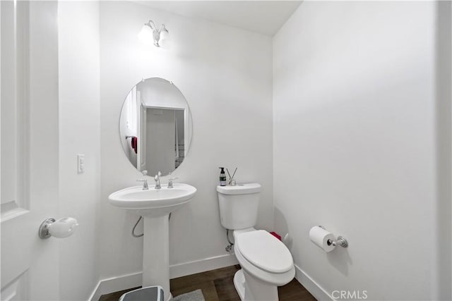 bathroom with sink, toilet, and hardwood / wood-style floors