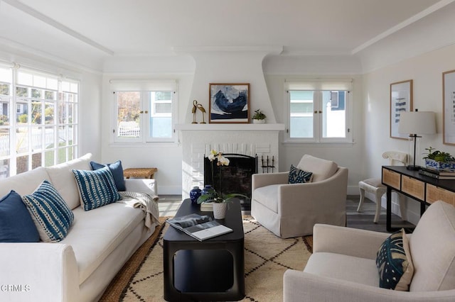 living room featuring a brick fireplace and light wood-type flooring