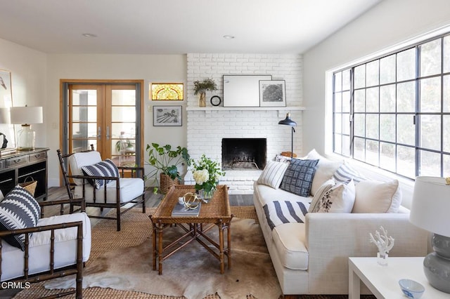 living room with french doors, a brick fireplace, and a wealth of natural light