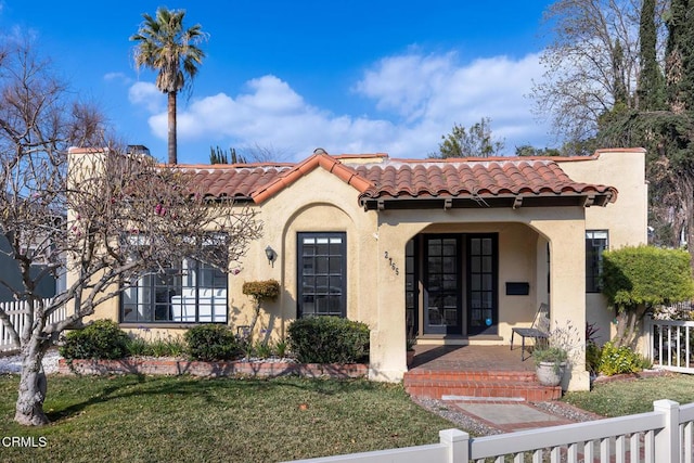 mediterranean / spanish home with a front lawn