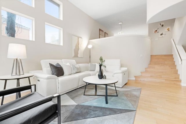 living room featuring a towering ceiling and light wood-type flooring