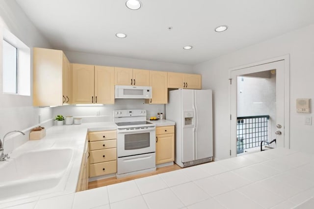 kitchen featuring sink, light brown cabinets, tile counters, and white appliances