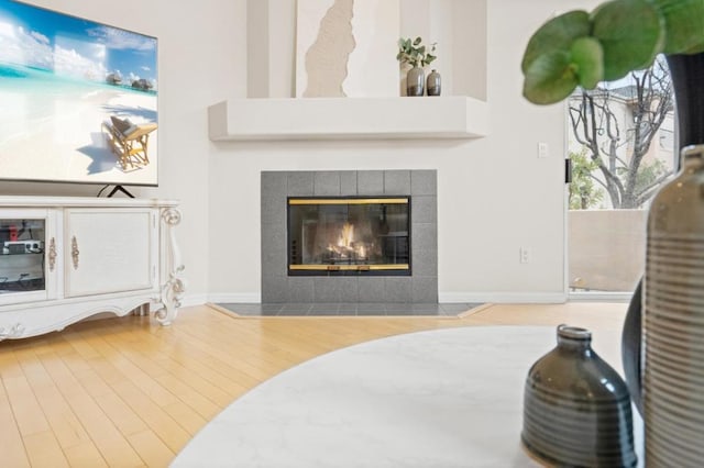 living room featuring wood-type flooring and a tile fireplace