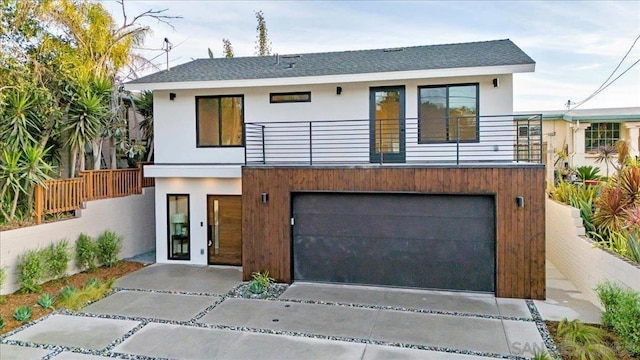 contemporary house featuring a garage and a balcony