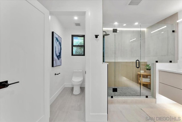 bathroom featuring vanity, an enclosed shower, and toilet