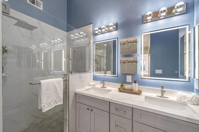 bathroom with vanity and tiled shower