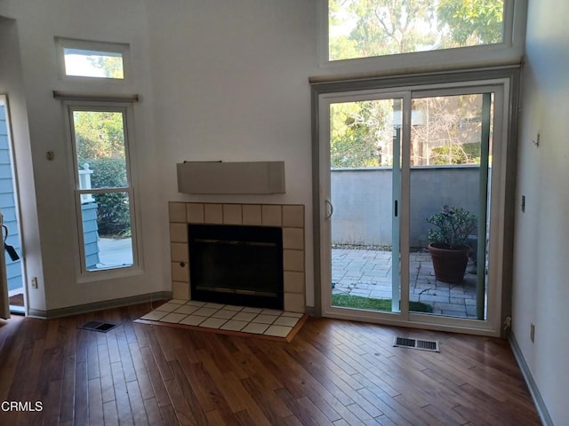 entryway featuring a tiled fireplace and dark hardwood / wood-style flooring