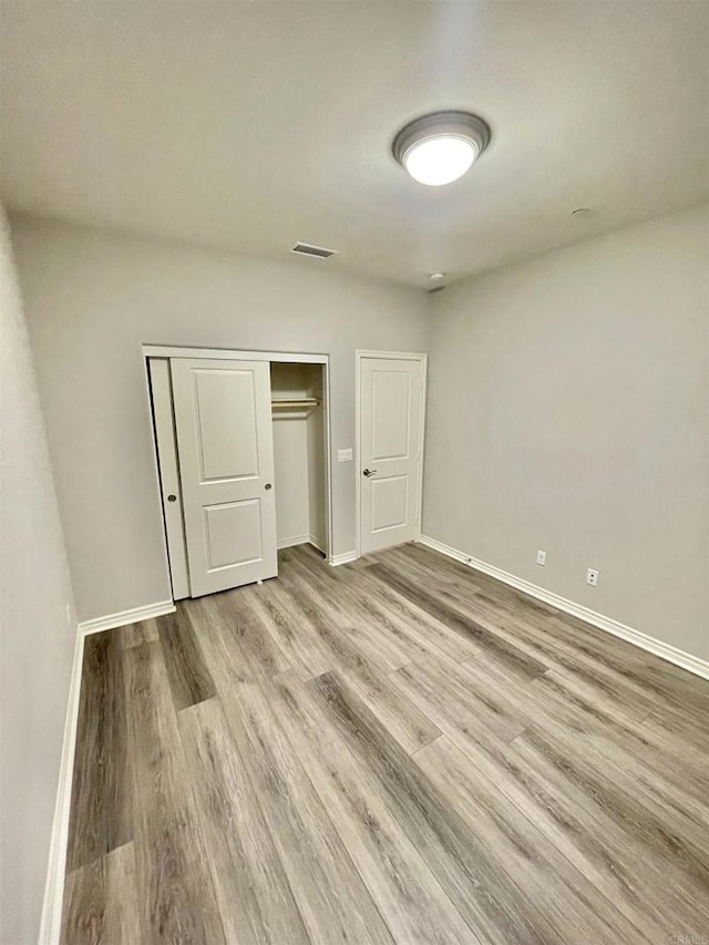 unfurnished bedroom featuring a closet and light wood-type flooring