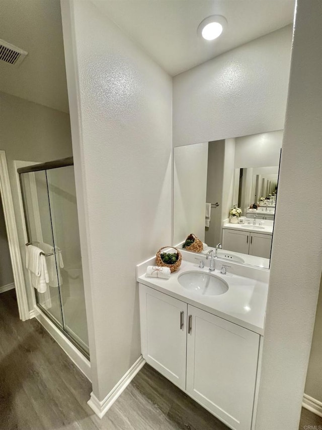 bathroom with vanity, hardwood / wood-style floors, and walk in shower