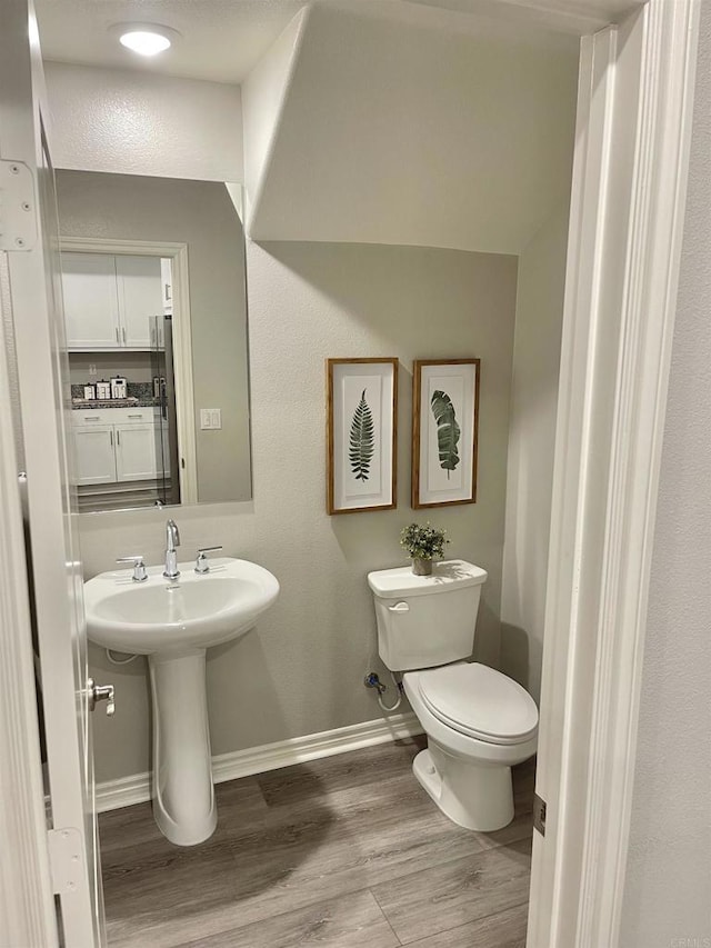 bathroom with sink, hardwood / wood-style flooring, and toilet