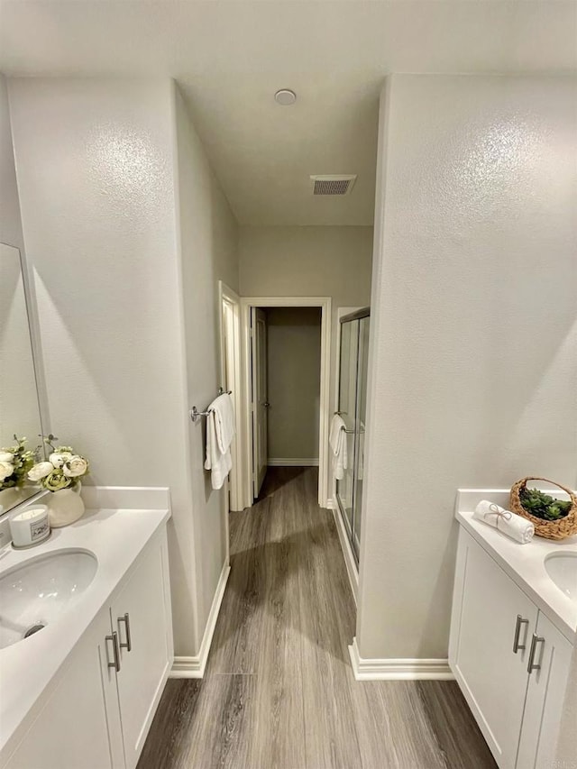 bathroom featuring vanity, wood-type flooring, and an enclosed shower