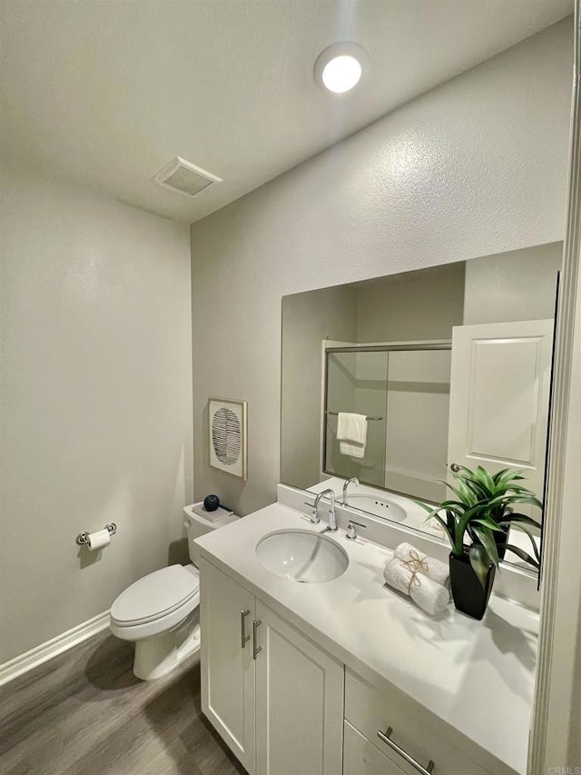 bathroom with vanity, toilet, and wood-type flooring