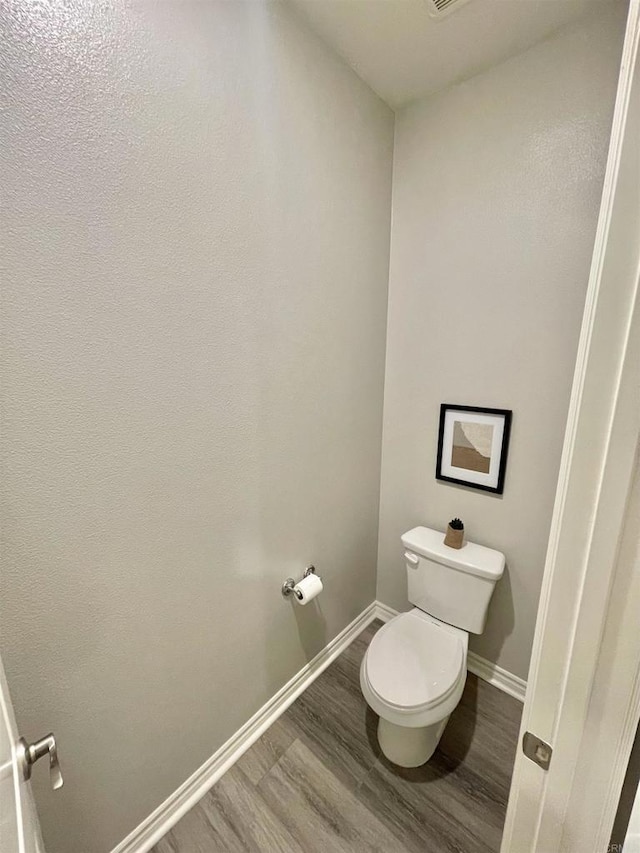 bathroom featuring hardwood / wood-style flooring and toilet