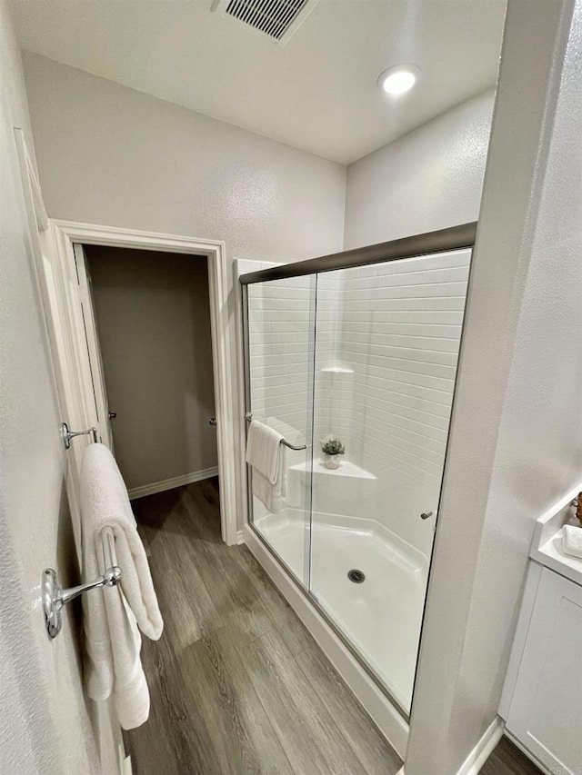 bathroom featuring a shower with door and hardwood / wood-style floors