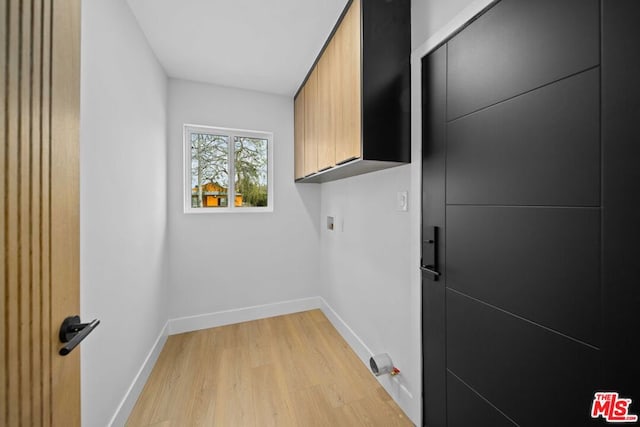 laundry area featuring hookup for a washing machine, cabinets, and light wood-type flooring