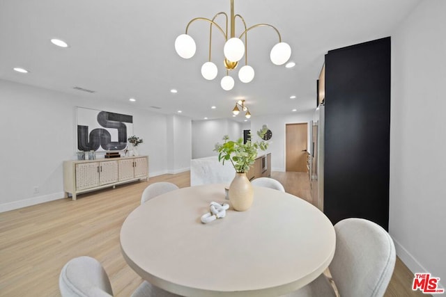 dining area featuring an inviting chandelier and light hardwood / wood-style flooring