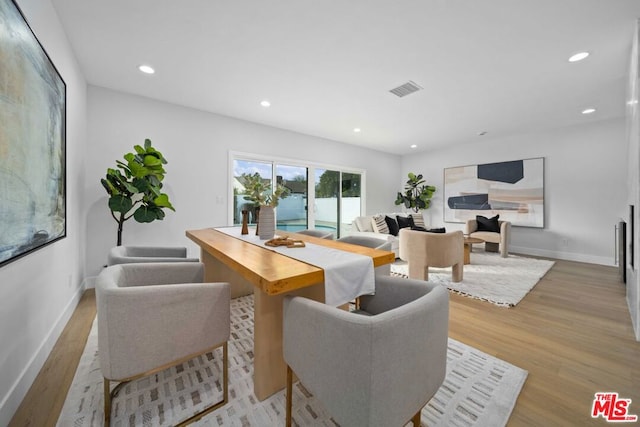 dining area with a fireplace and light hardwood / wood-style flooring