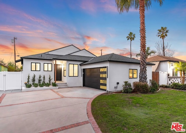 view of front of house featuring a garage and a lawn