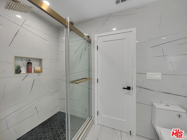 bathroom with walk in shower, toilet, and tile walls