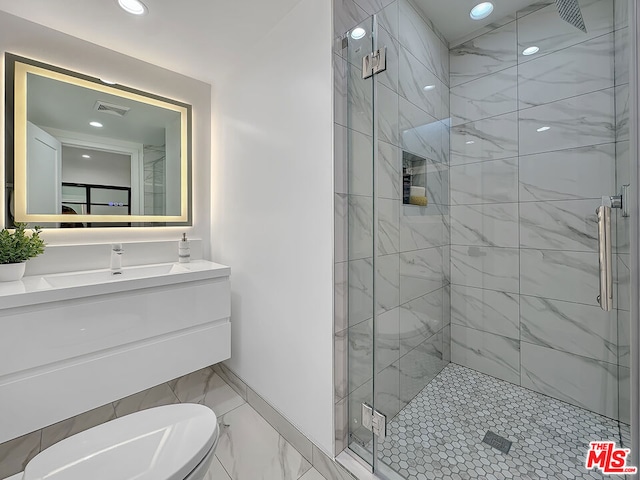 bathroom featuring vanity, a shower with shower door, and toilet