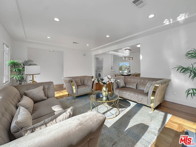 living room featuring wood-type flooring and washer / dryer