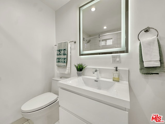 bathroom featuring vanity, a shower with shower door, and toilet