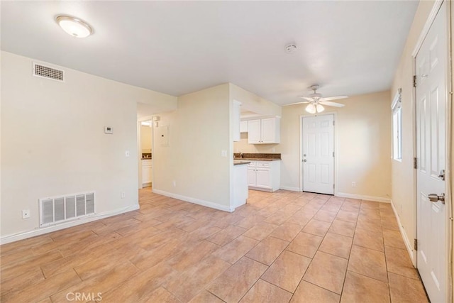 unfurnished living room with ceiling fan and light wood-type flooring