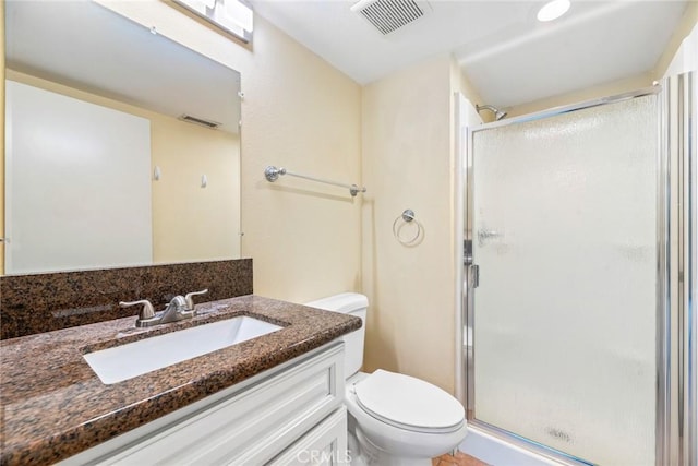 bathroom featuring walk in shower, vanity, and toilet