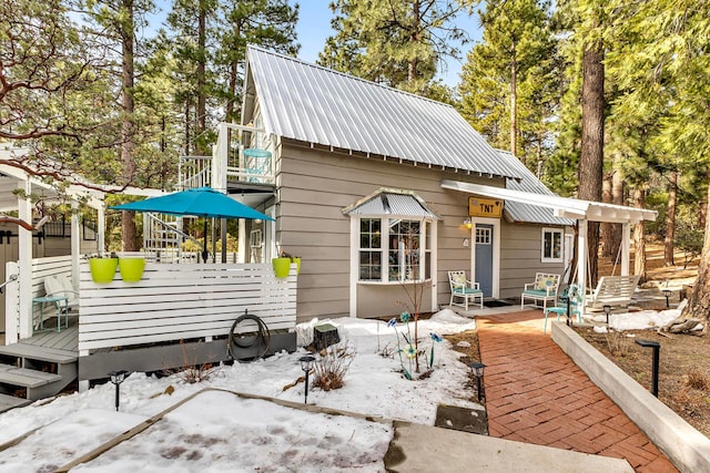 exterior space featuring a wooden deck and a patio