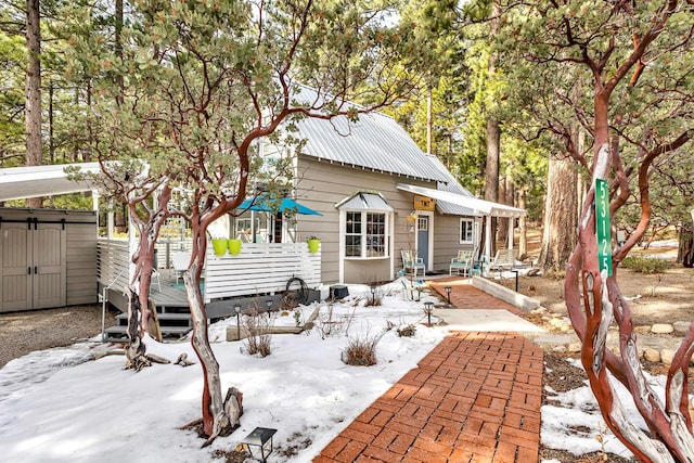 snow covered rear of property featuring a deck