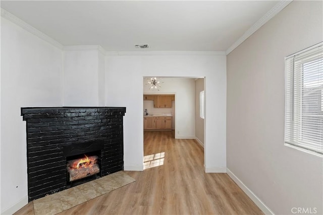 unfurnished living room featuring a brick fireplace, light hardwood / wood-style flooring, ornamental molding, and sink