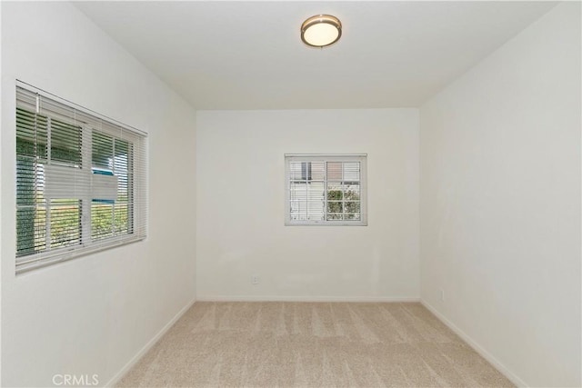 spare room featuring light colored carpet