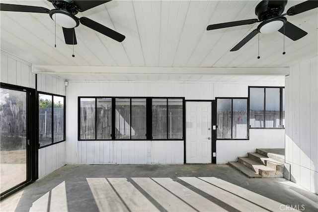 unfurnished sunroom with ceiling fan