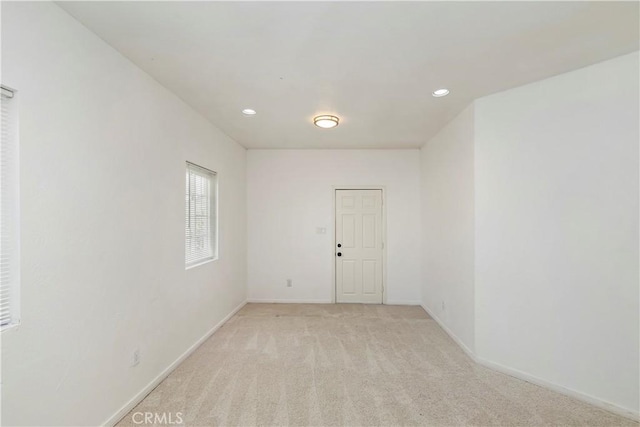 unfurnished room featuring light carpet