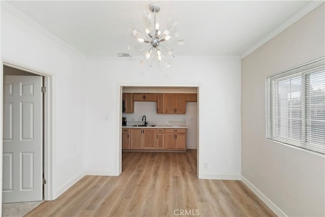 interior space featuring crown molding, sink, a notable chandelier, and light hardwood / wood-style flooring