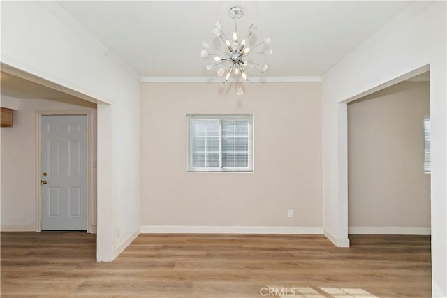 unfurnished dining area featuring ornamental molding, a wealth of natural light, an inviting chandelier, and light hardwood / wood-style floors