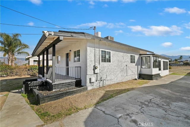 view of side of property featuring a mountain view and covered porch