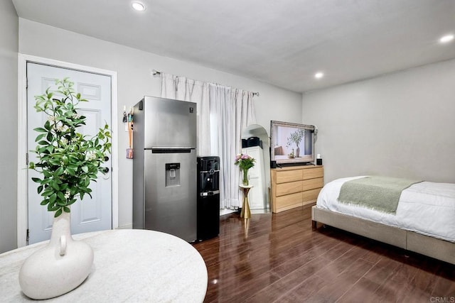 bedroom featuring stainless steel refrigerator with ice dispenser and dark wood-type flooring