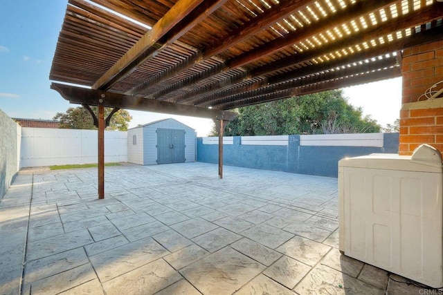 view of patio featuring a shed, a pergola, and washer / dryer