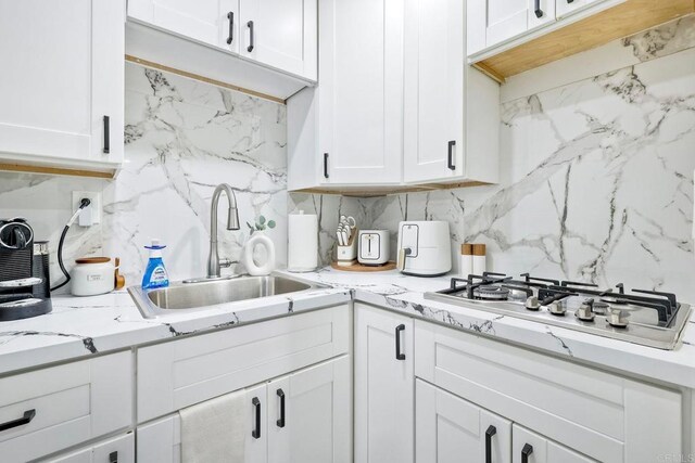 kitchen featuring white cabinetry, sink, and gas cooktop