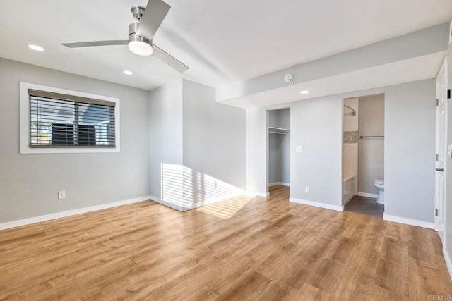 interior space with ceiling fan, a closet, connected bathroom, and light hardwood / wood-style flooring