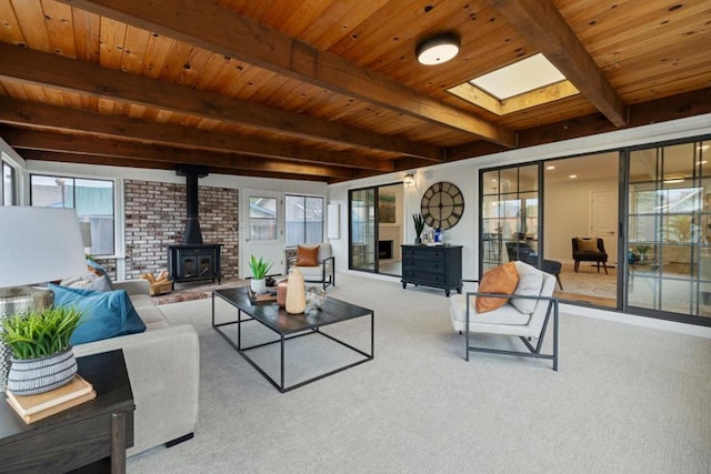 carpeted living room with a wealth of natural light, beamed ceiling, and a wood stove