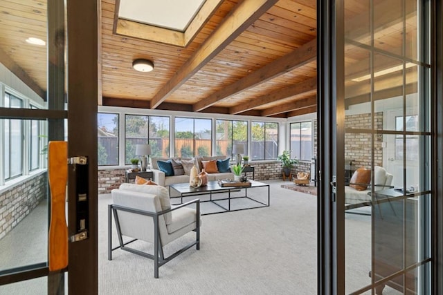 sunroom / solarium with beam ceiling, a skylight, and wooden ceiling