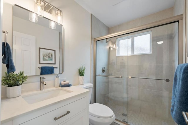 bathroom featuring vanity, toilet, and an enclosed shower